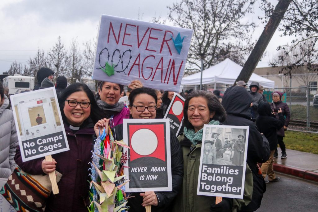 Image of protesters holding signs outside of the Northwest Detention Center.