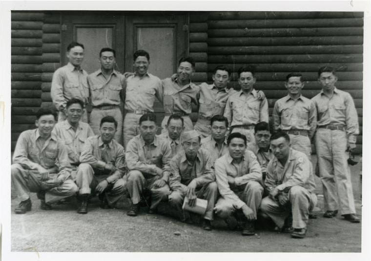 Black and white photo of Japanese Americans at the Military Intelligence Language School during WWII. The men are wearing khaki uniforms and posing in two rows, those in the front row kneeling and those in the back standing.