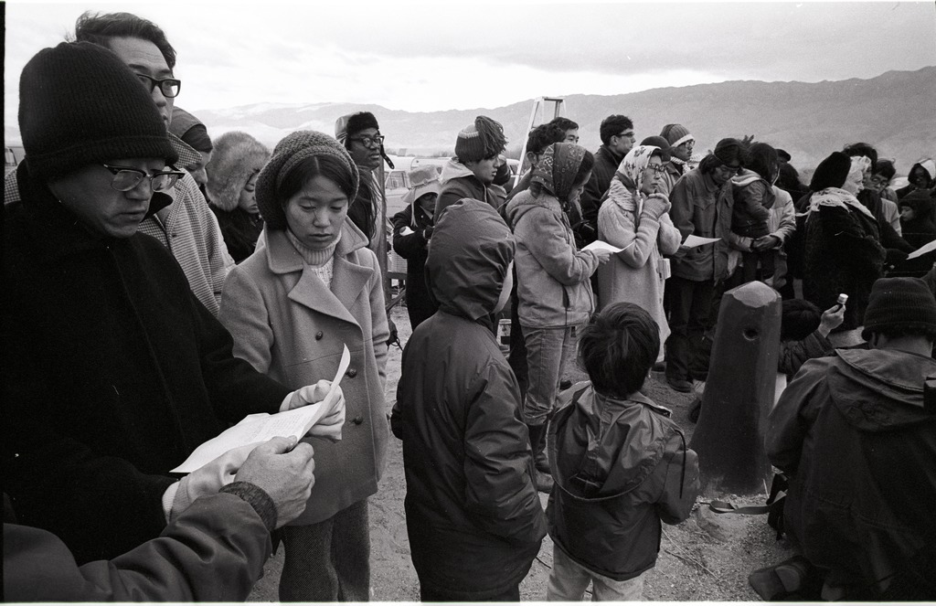 An intergenerational group of people gathered to listen to the pilgrimage ceremony.
