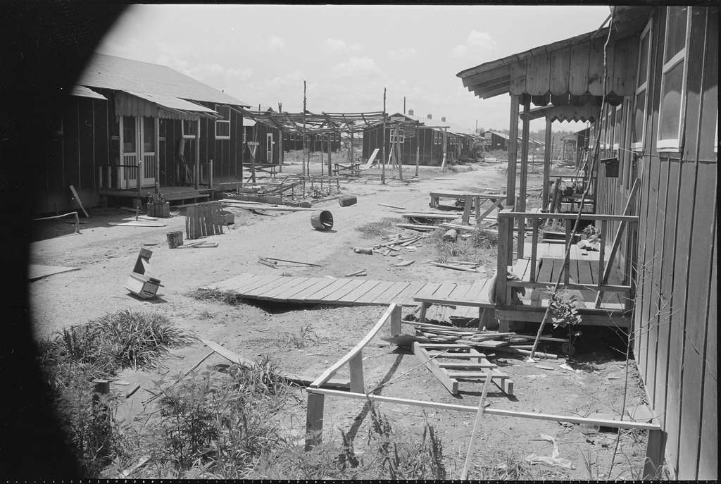 An empty block of barracks with lumber strewn on the ground in Jerome after closing.
