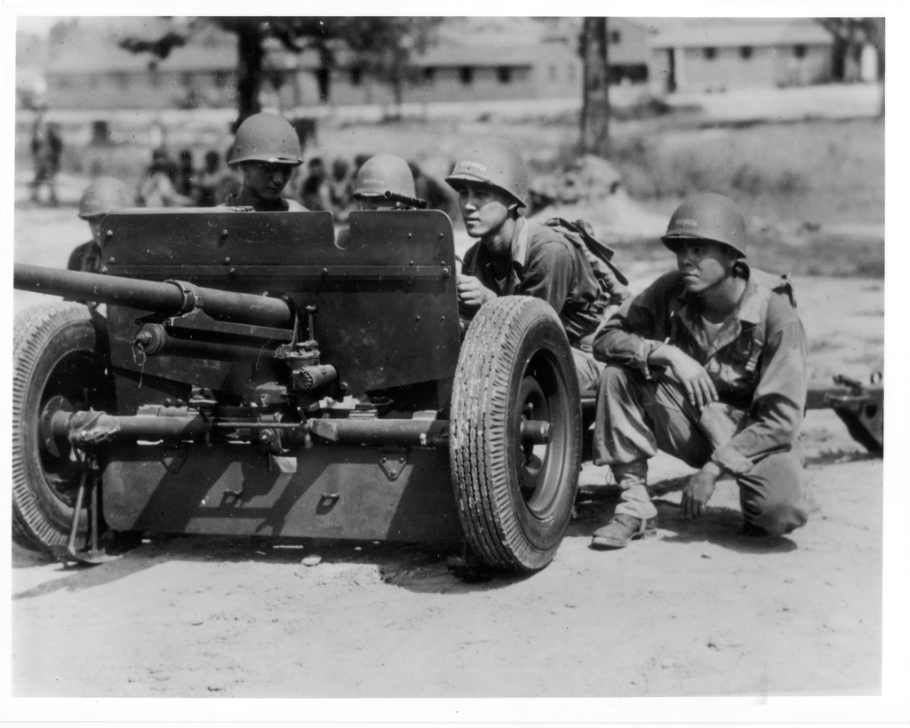 Four Japanese American soldiers training with an antitank artillery gun in Camp Shelby.